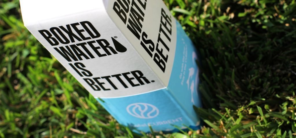 Boxed Water Is Better water container wrapped with custom designed blue Hotel Current sleeve.