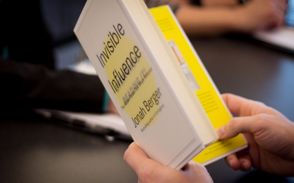 person reading invisible influence book 