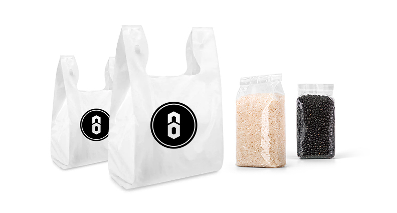 Grocery bags with the Brandastic logo standing next to bags of rice and beans.