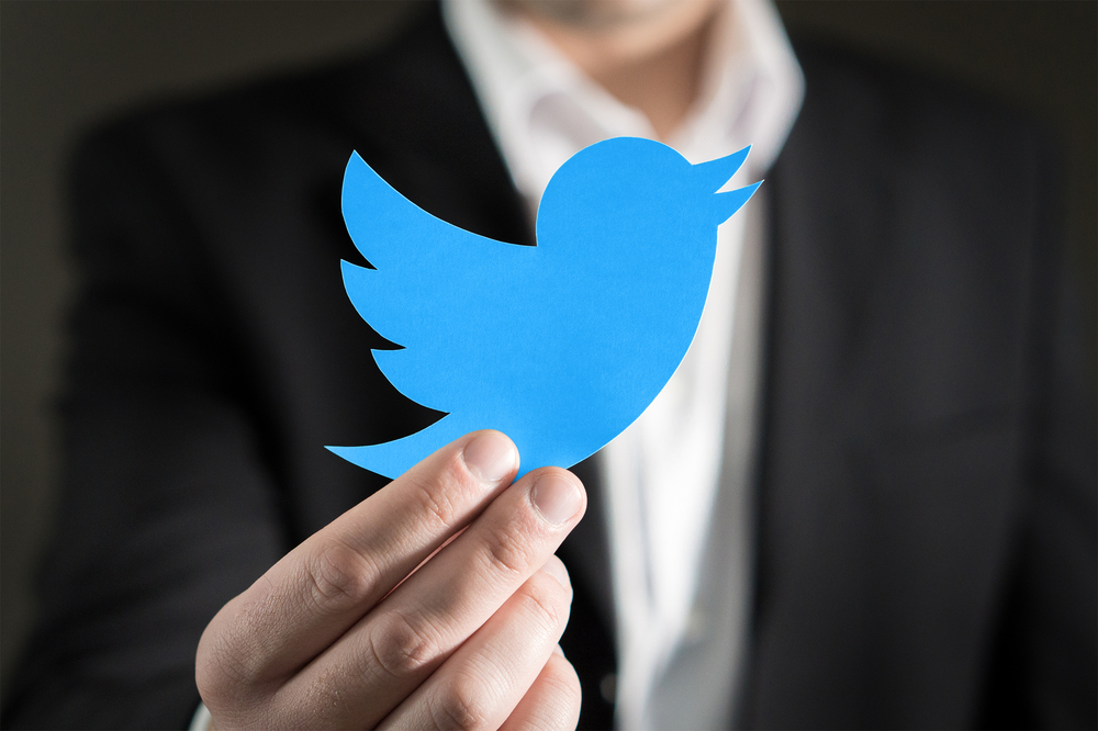 man holding twitter logo