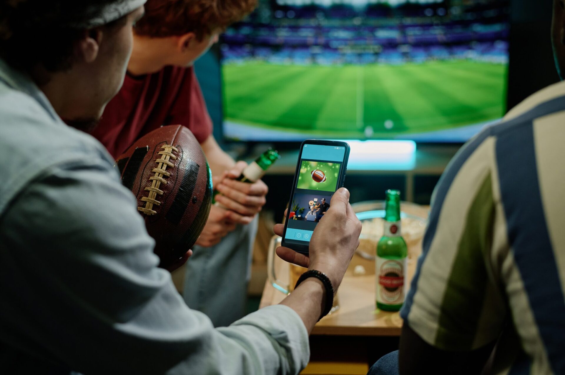 Group of friends watching the Super Bowl game on the TV and phone getting served a programmatic ad from Brandastic.