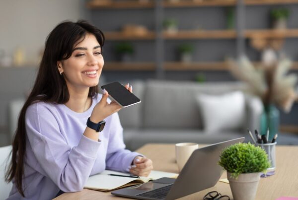 Women using voice search while doing work on the laptop